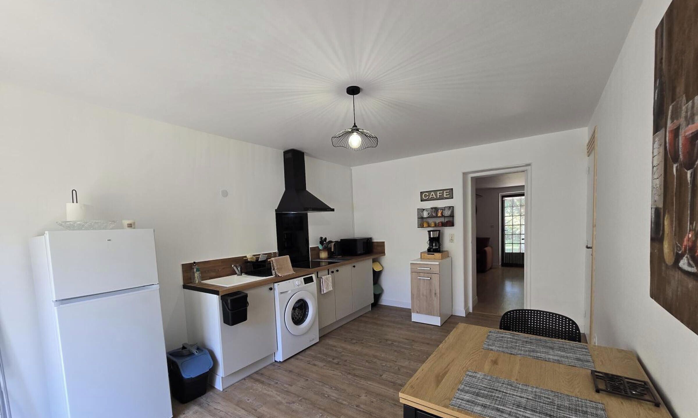 A compact kitchen with a washing machine, a microwave, and a coffee maker.