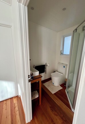 A bathroom with a toilet, sink, and shower.