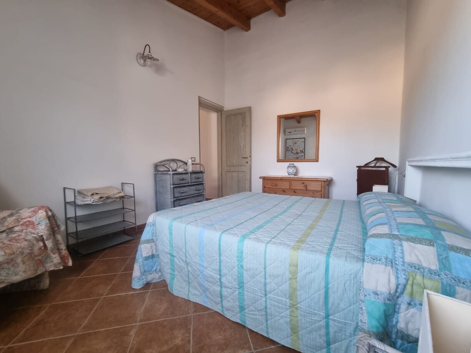 Un dormitorio con cama, cómoda y espejo.