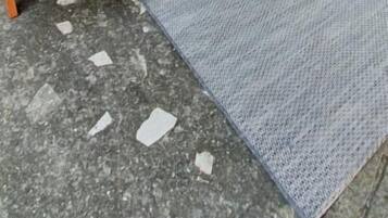 Un patio con dos sillones, una mesita y una botella.