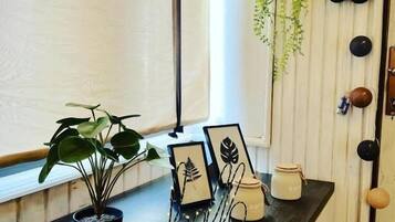 A kitchen counter with a potted plant, framed pictures, and a candle holder.