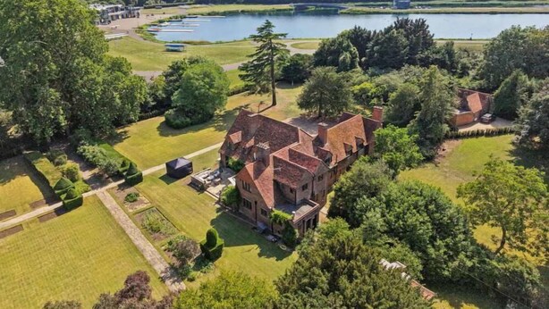 Una extensa propiedad con varias edificaciones, un lago y un jardín cuidado.