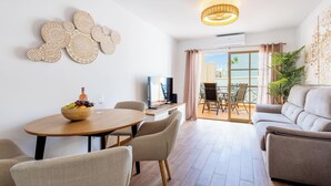 Un soggiorno moderno con zona pranzo, televisione e balcone con vista.