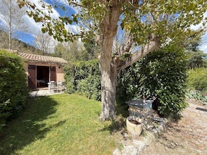 A rustic building with a tiled roof, a stone bench, and a tree in the foreground. - In the heart of the Verdon, with a terrace and garden! (Castellane)
