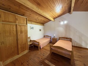 A room with wooden floors, two wooden beds, a wardrobe, and a desk. - Spacious Studio in Castellane (Castellane)
