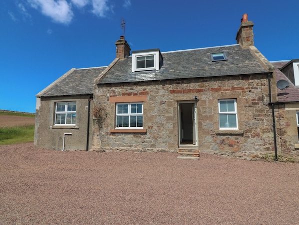 A stone house with two windows, a door, and a small porch area. - Keepers Cottage (Haddington)