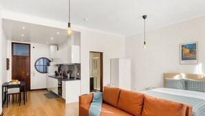 Eine moderne Wohnung mit Küche, Essbereich und einem Schlafzimmer mit Bett und Nachttisch.