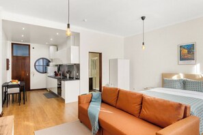 Eine moderne Wohnung mit Küche, Essbereich und einem Schlafzimmer mit Bett und Nachttisch.