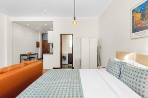 Ein Hotelzimmer mit einem Bett, einer Sitzecke, einem Essbereich und einer Waschgelegenheit.