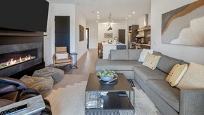 A modern living room with a fireplace, a sofa, a coffee table, and a television. - Villa 2 at Troon North, Luxury Golf Villa with Shuffleboard + Poker (Scottsdale)