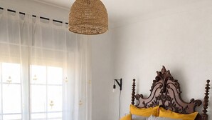 A bedroom with a bed, wooden headboard, and a hanging light fixture. - One-bedroom apartment facing the ocean (Leiria)