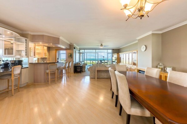 A spacious kitchen with a dining area, large windows, and a view of the outdoors.