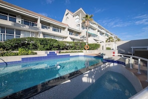 Hotel com piscina, palmeira e boia.