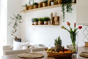 Ein Esstisch mit einer Obstschale, einer Blumenvase und einer klaren Glasvase.