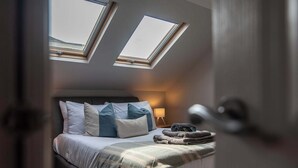 A bedroom with a bed, pillows, a lamp, and a window. - Central, Secure Parking and High-end (Nottingham)