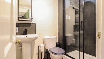 Ein Badezimmer mit Waschbecken, Toilette und Dusche.