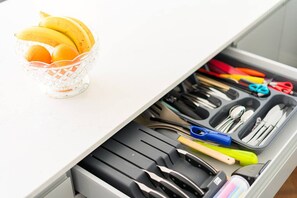 A kitchen drawer with utensils and a glass bowl containing bananas and oranges. - The Pontcanna Jewel on Cathedral Road (Cardiff)