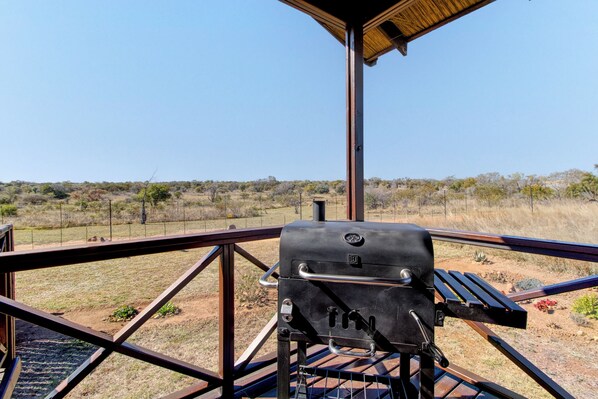Una parrilla de barbacoa en un balcón con vistas a un paisaje árido.