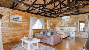 Un intérieur en bois comprenant un lit, un canapé, une petite table et un miroir.