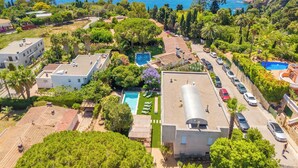 Uma área residencial à beira-mar, com piscina, vários edifícios e vista para o oceano.
