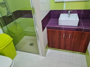 Ein Badezimmer mit Dusche, Toilette und Waschbecken.