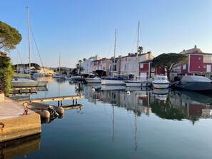 A marina with boats docked, calm water, and buildings in the background. - Studio in the heart of Port Grimaud, 7 minutes from the beach + gorgeous view (Grimaud)