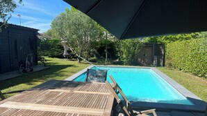 En swimmingpool med ett trädäck och ett överbyggt område.