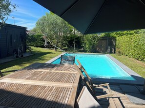 A swimming pool with a wooden deck and a covered area. - 4-Bedroom House—Pool—Private Parking, Air Conditioning, Historic City Center 10-Minute Walk Away (Bergerac)