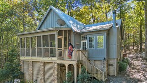 A cabin with a balcony, a flag, and a chimney. - New! 2 bedroom/2 bath water access cabin at Lake Martin! Sleeps 8! (Dadeville)