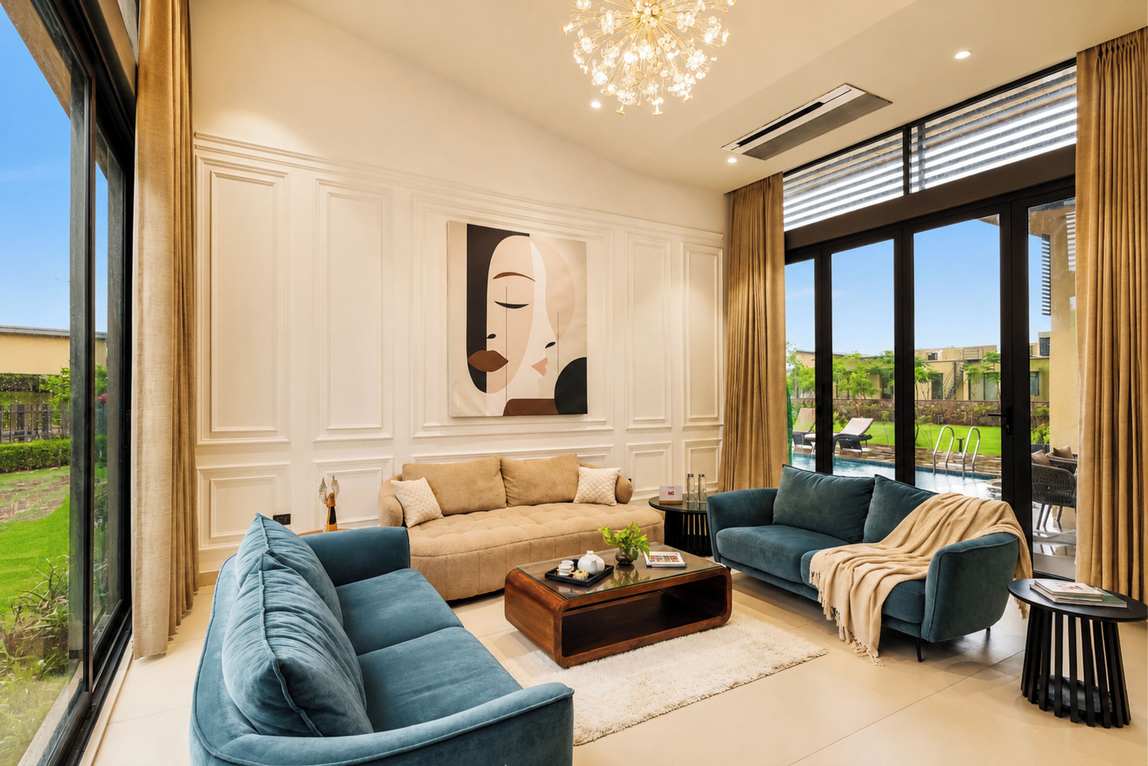 Una sala de estar moderna con un sofá, sillones, una mesa de centro y un ventanal con vistas a una piscina.