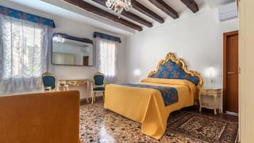 Un dormitorio con cama, una silla, un escritorio, un espejo y una araña.