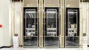 A modern interior with a black and gold color scheme, featuring a central glass partition with shelves and a marble floor. - Nest One (Tashkent)
