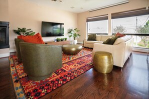 A modern living room with a sofa, coffee table, and decorative plants. - 3-bedroom, 4-bed townhome, steps from Downtown Houston (HOUSTON)