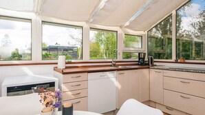 Una cocina moderna con ventanas amplias, lavavajillas y cafetera.
