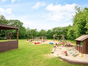 A playground with swings, slides, and climbing structures. - 4 Person Holiday Home in Farvang (Farvang)