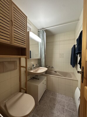 Ein Badezimmer mit Toilette, Waschbecken und Badewanne.