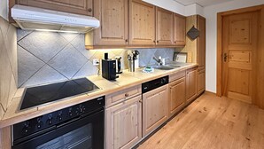 Una cocina moderna con armarios de madera, estufa integrada y lavavajillas.