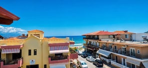 Ein Hotel an der Küste mit Balkonen, Blick auf den Strand und blauem Himmel.