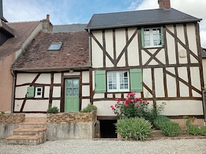 Ein traditionelles Fachwerkhäuschen mit Ziegelverkleidung, einem Satteldach und einem kleinen Fenster.