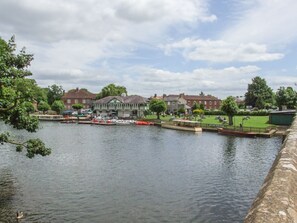 A riverside view with a dock, boats, and a green building with a sign that says 'OPEN'. - The Bolt Hole (Stratford-upon-Avon)