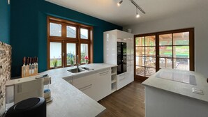 A modern kitchen with a large window, wooden cabinets, and a built-in oven.