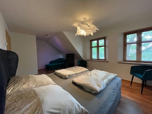 Un dormitorio con cama, una silla, un escritorio, una ventana y una lámpara en el techo.
