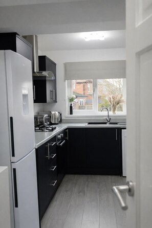 Een moderne keuken met een inbouwfornuis, oven en magnetron.