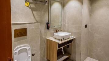 Un bagno moderno con WC, lavandino e specchio.