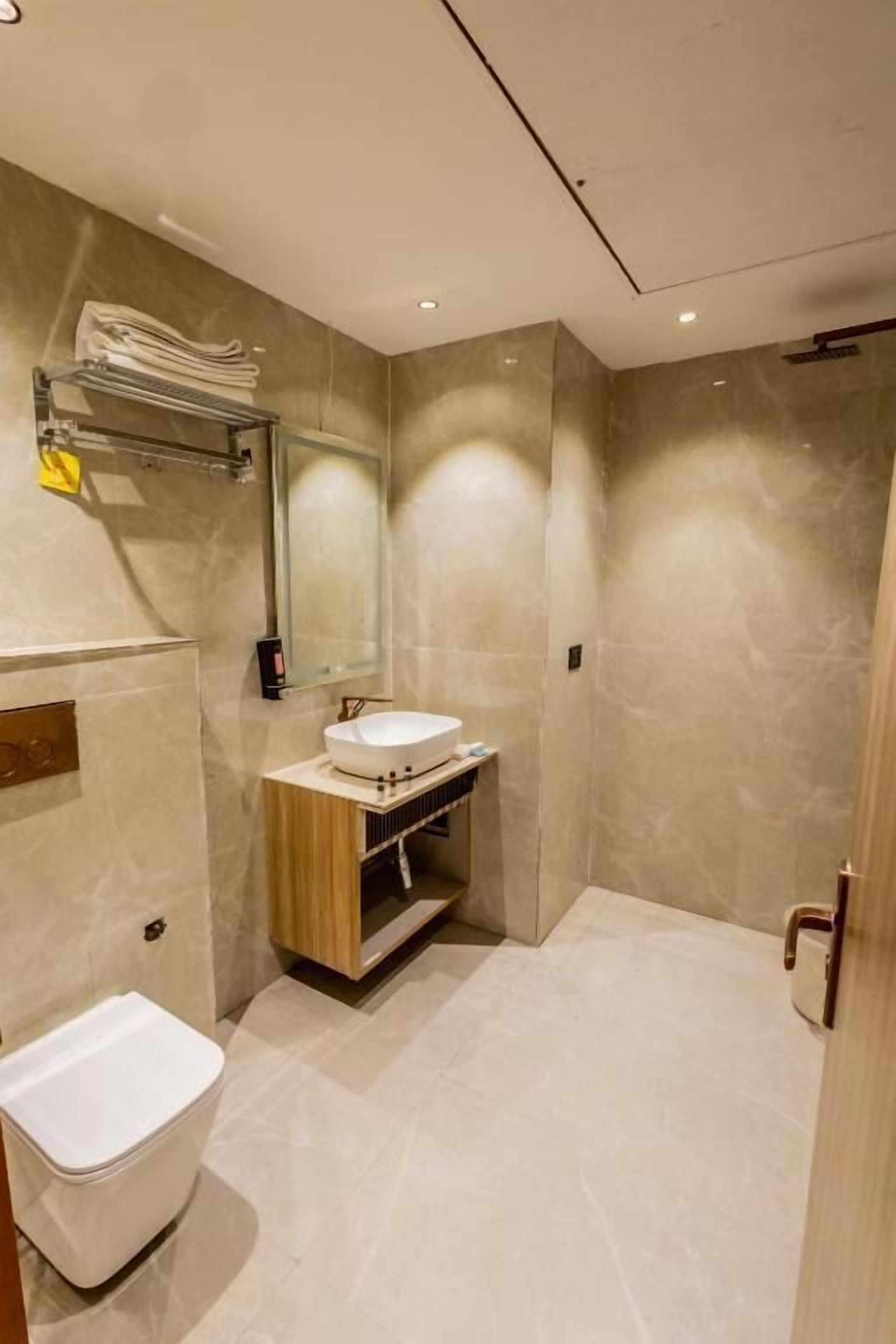 Ein modernes Badezimmer mit Toilette, Waschbecken und Spiegel.