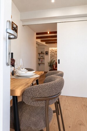 Een eethoek met een houten tafel en gestoffeerde stoelen.