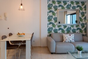 A room with a dining table, chairs, a sofa, a mirror, and a plant on a glass table. - Sara 5, Playa Blanca (Playa Blanca)