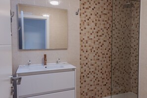A bathroom with a white sink, a mirror, and a shower with mosaic tile walls. - Sara 5, Playa Blanca (Playa Blanca)