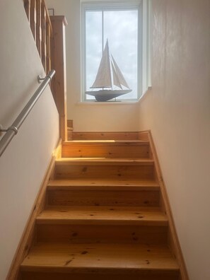 A wooden staircase with a sailboat model on a windowsill. - Rosgorm Cottage - Coastal Retreat, Islay (Port Charlotte)