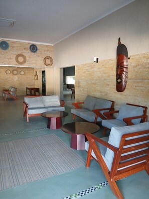 Un vaste espace de vie comprenant un canapé, des fauteuils et une table basse.